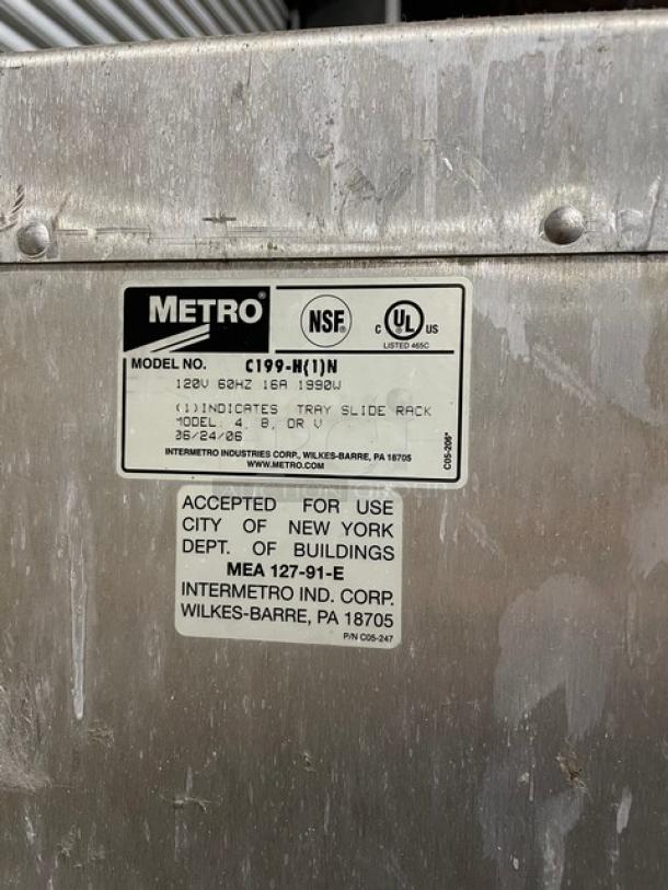 Metal industrial equipment with Metro label, model C199-H(1)N, 120V, certified by NSF and UL. Approved for NYC use. Signs of wear.
