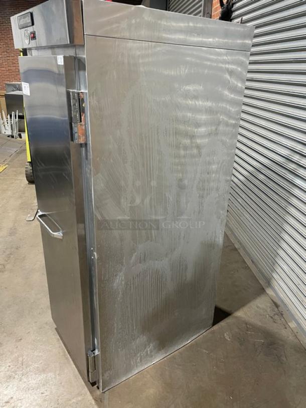 Stainless steel commercial refrigerator, single door, visible surface marks, clean modern design, good used condition.