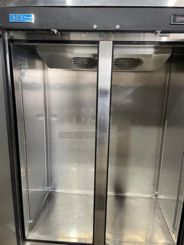 Double-door stainless steel commercial refrigerator, model W18, in excellent condition. Interior shelves and cooling vents visible.