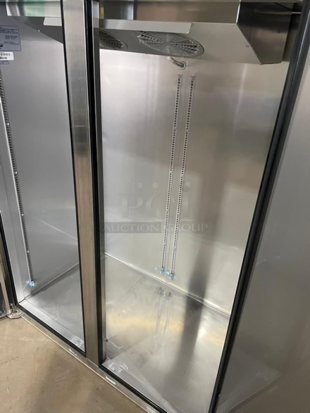 Commercial stainless steel display refrigerator, glass doors, top cooling fans, interior shelf rails, excellent condition.