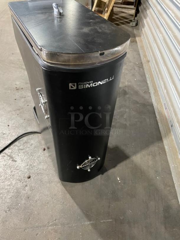 Nuova Simonelli commercial coffee grinder, black, stainless top, visible cord, branded panel. Good condition.