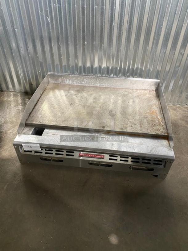 Commercial griddle from American Range, used, with visible rust and wear. Model label in front. Lot number 15.