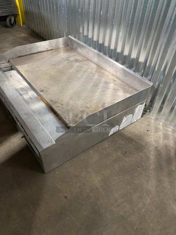 Large industrial metal platform scale in used condition, metallic finish with side panels. Some surface rust visible.