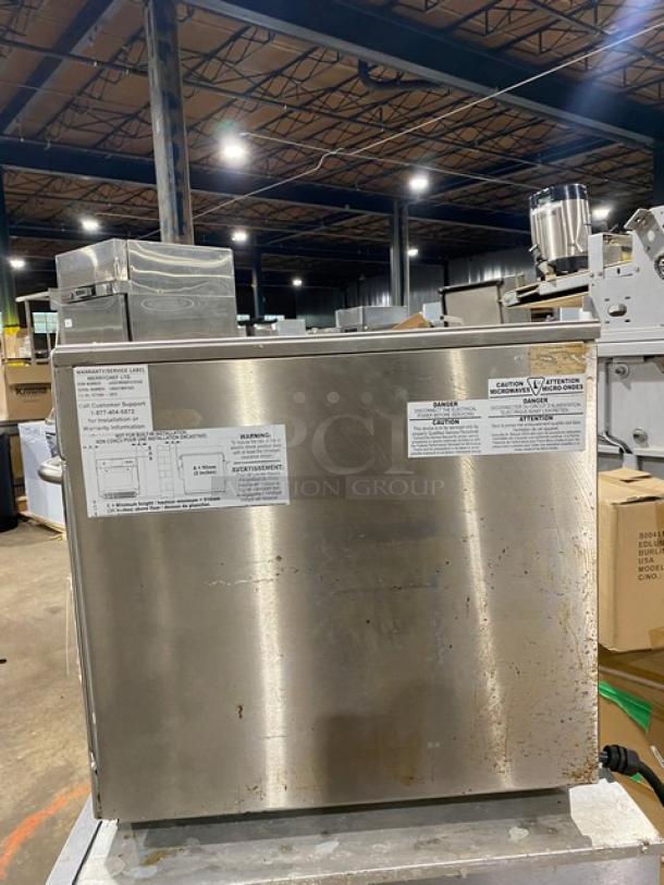 Industrial stainless steel kitchen appliance, verified by instructional and warning labels on the front. Visible wear indicates used condition.