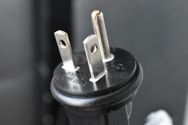Close-up of a three-prong electrical plug with labeling "E127181 LIAN DUNG," in good condition.