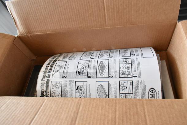 Large instruction manual in open cardboard box, showing operating procedures and illustrations. AMA logo on the document.