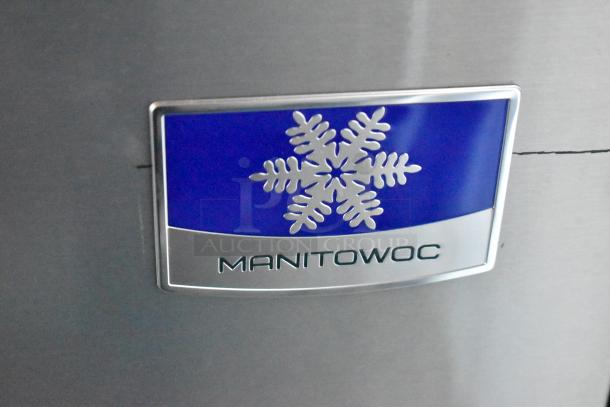 Manitowoc logo on stainless steel appliance, featuring a blue and silver snowflake design.