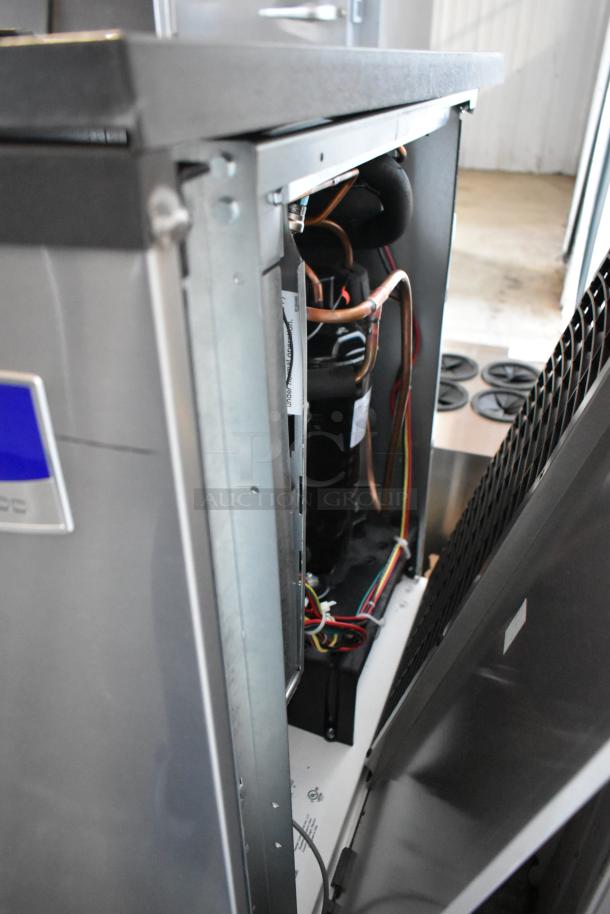 Industrial ice maker with exposed interior, showing wiring and copper tubing. Metal casing is partially open. Good condition.