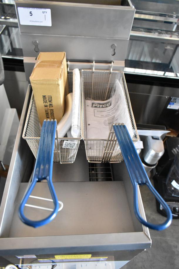Commercial deep fryer with two metal baskets, blue handles, and accessories. Box labeled "Made in Taiwan" and instruction manual included.