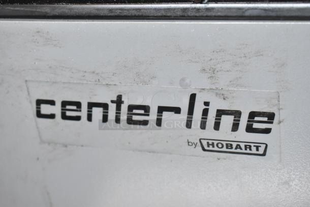 Hobart Centerline logo on a white appliance surface, showing moderate wear and dirt, indicating use.