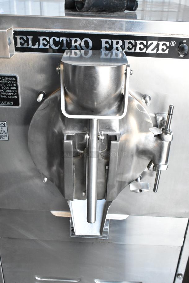 Electro Freeze ice cream machine in stainless steel, featuring dispensing lever and control panel. Appears in good condition.