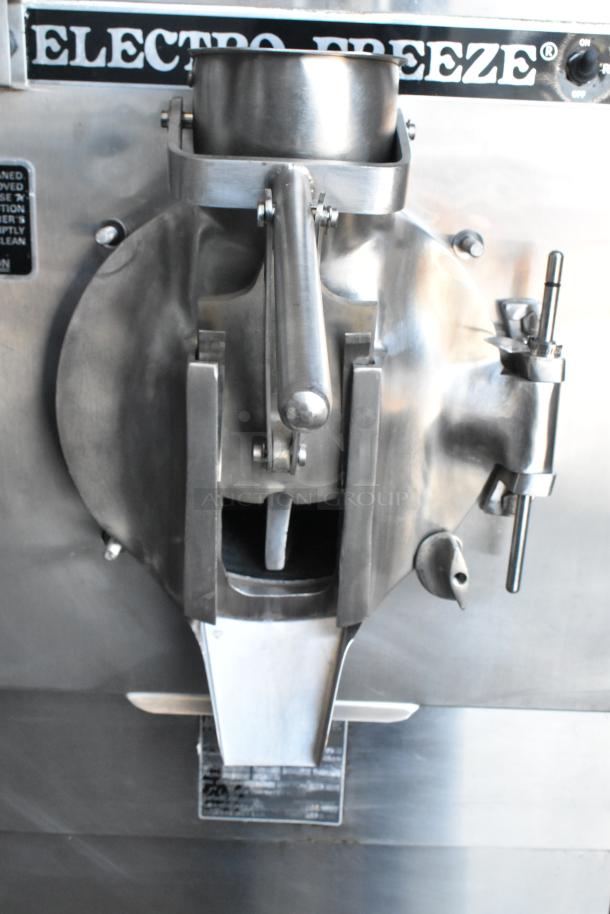 Electro Freeze ice cream machine, stainless steel with manual lever and visible brand label, in used condition.