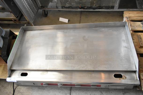 Commercial stainless steel griddle, large flat cooking surface, slightly used condition, visible rear ventilation holes.