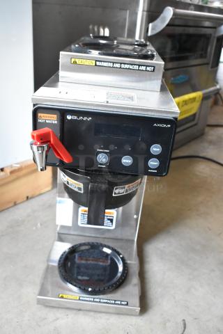 Bunn Axiom coffee brewer, stainless steel, red hot water handle, caution labels, digital display, used condition.