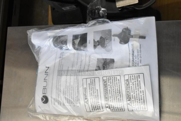 Bunn sprayhead cleaning kit in sealed packaging with instruction manual and warning labels showing usage instructions.