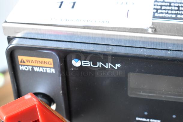 Bunn commercial coffee machine with hot water warning, stainless steel top, and visible brand logo, in used condition.