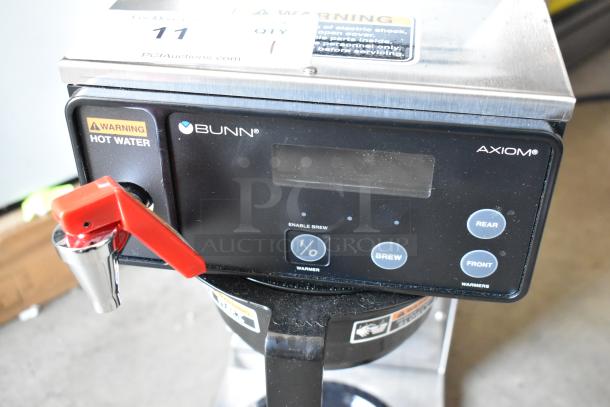 Bunn Axiom coffee brewer with digital display, red hot water tap, and warning labels. Used condition, model information visible.