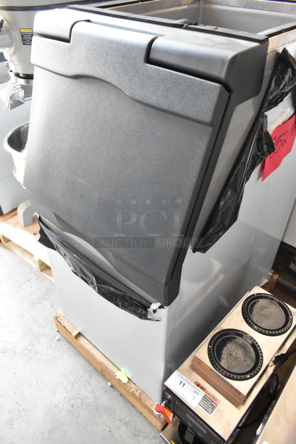 Commercial ice machine with black and silver casing, in good condition. Includes visible label with auction lot number 11.