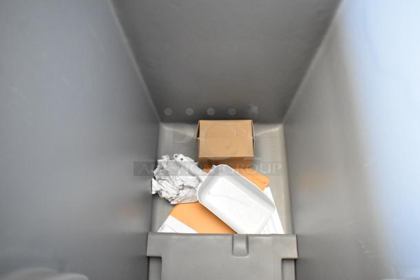 Bin with a cardboard box, crumpled paper, dustpan, and envelopes inside; clean condition.