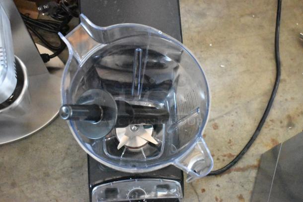 Top view of a clear blender pitcher on a black base with sharp blades and a handle. Control knob visible. Appears in good condition.