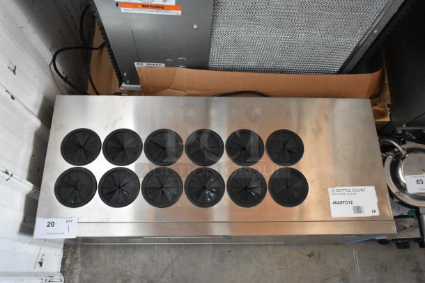 Stainless steel countertop wine cooler with 12 circular bottle openings, black flaps, and label indicating model #46ASTC12.