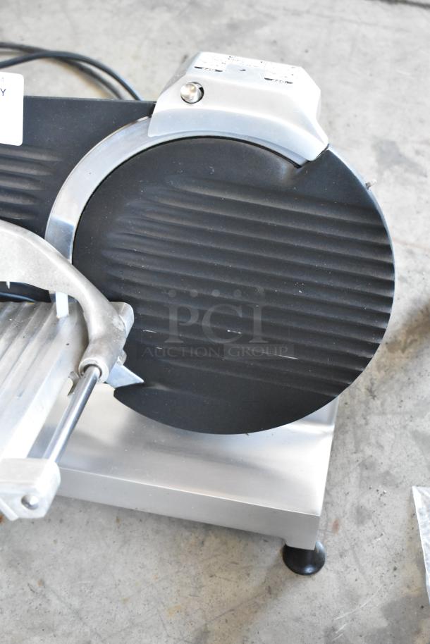 Electric meat slicer with black blade guard, stainless steel base, and adjustment knob; appears in good condition.