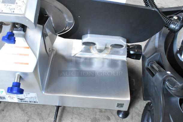 Commercial deli slicer, stainless steel, adjustable blade, used condition. Labels indicate UL listed, model details.