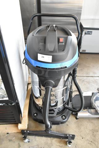 Industrial vacuum cleaner, stainless steel body, black and blue accents, wheeled base, condition appears used. Label: "24 QTY 1".