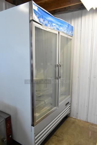 Commercial glass door refrigerator with dual doors, stainless steel frame, and ice-themed top panel, in good condition.