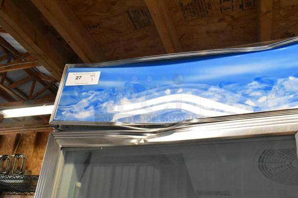 Commercial glass door freezer, stainless steel frame, in good condition. Label shows auction number 27, quantity 1.