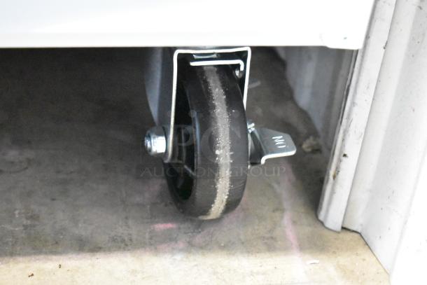 Heavy-duty caster wheel with metal mounting bracket and foot brake. Shows wear indicative of use.