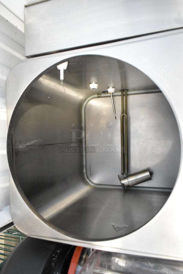 Stainless steel commercial ice cream machine interior, showing dispensing nozzles and mixing components. Clean condition.