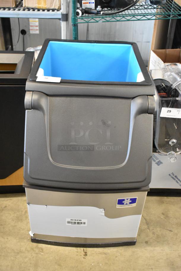 Manitowoc ice storage bin, model D320, stainless steel with blue interior, minor exterior scuffing, auction tag on top.