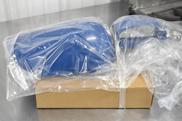 Blue plastic automotive parts in clear plastic packaging, resting on a cardboard box, showcasing new condition.