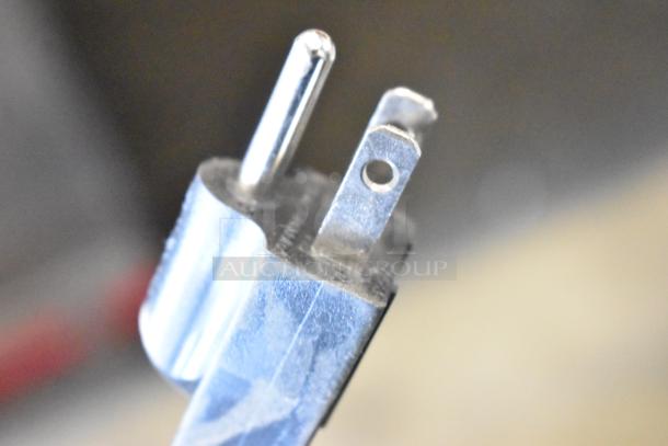 Close-up of a silver metal electric plug with three prongs, showing signs of wear. Ideal for replacement or repair.