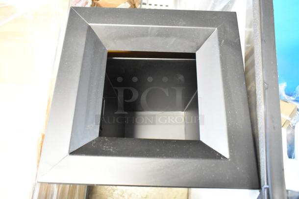 Black square metal bin, open top, with angled edges. Appears in good condition. Used for waste or storage purposes.