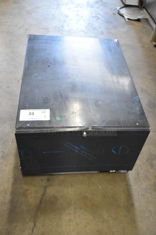 Black metal box with protective film, showing a label with "33 QTY" and "PCI Auctions"; in likely new condition.