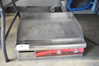 Commercial stainless steel griddle with dual knobs, slightly used condition, visible lot tag "34 QTY 1."