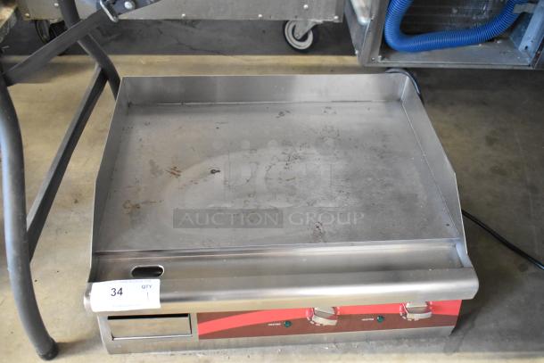 Commercial stainless steel flat-top griddle with dual temperature knobs, showing signs of use. Auction tag "34".