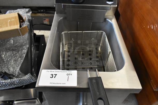 Stainless steel deep fryer with basket, model 37, in used condition. PCI Auctions tag visible. Complete with plug and handle.