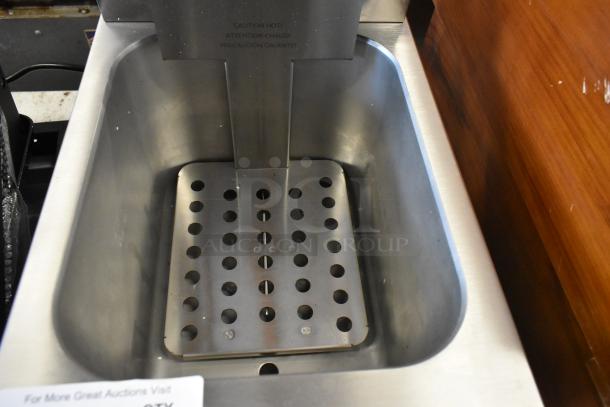Stainless steel commercial warming bin with perforated insert, good condition. "Caution Hot" label visible.