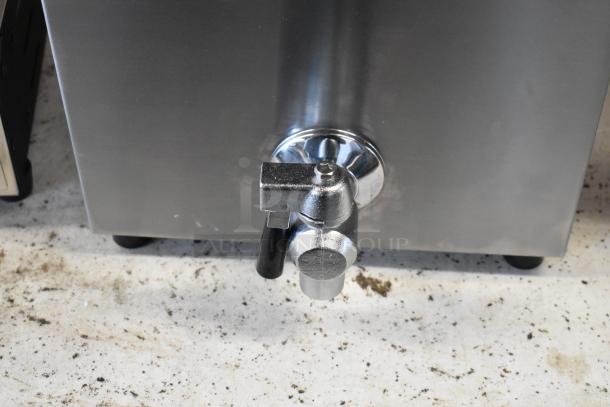 Stainless steel commercial beverage dispenser faucet, slight wear, metal construction, suitable for catering or events.
