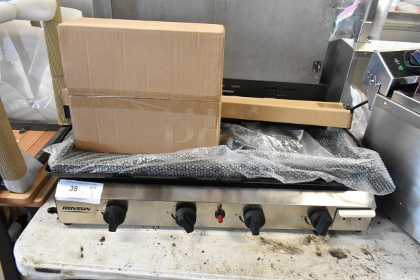 Rovsun commercial gas griddle with four controls, boxed accessories, and bubble wrap. Item label "38" visible.