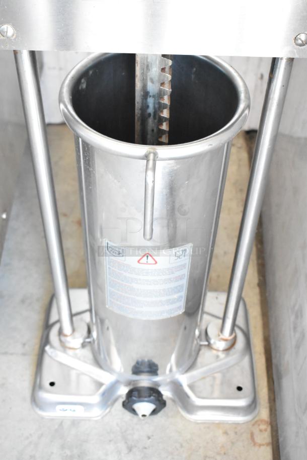 Stainless steel sausage stuffer, industrial-grade, with gear mechanism. Features safety label and adjustment knob, excellent condition.