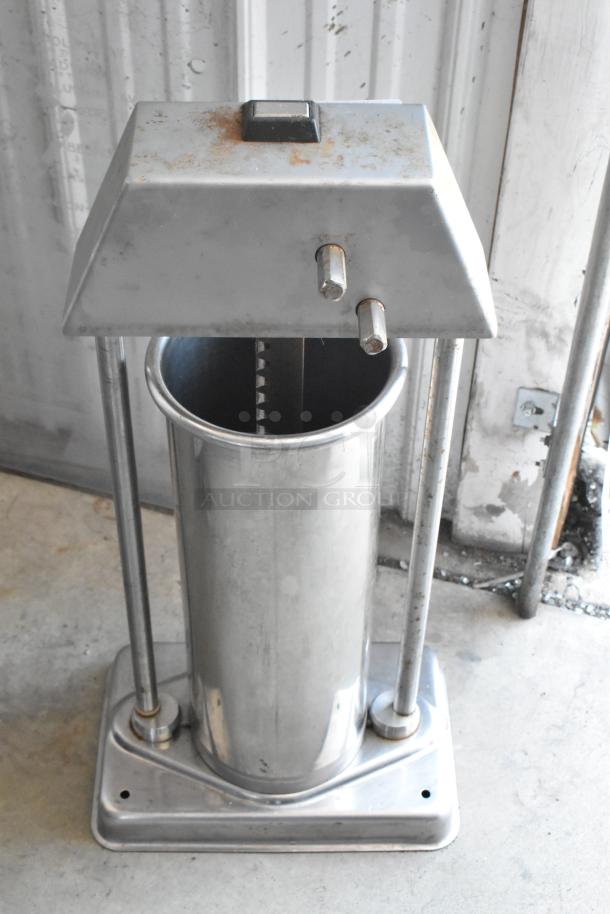 Stainless steel sausage stuffer with rust marks on top. Features dual handles and gears. Sturdy base.