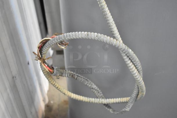 Frayed electrical conduit with exposed wires, showing signs of wear. Ideal for scrap or repair projects.