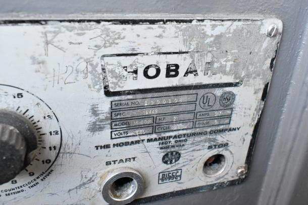 Close-up of a Hobart mixer label, model M-802, serial 1900108. Specs: 3-phase, 200 volts, 60 cycles, 3.7 amps. Worn condition.