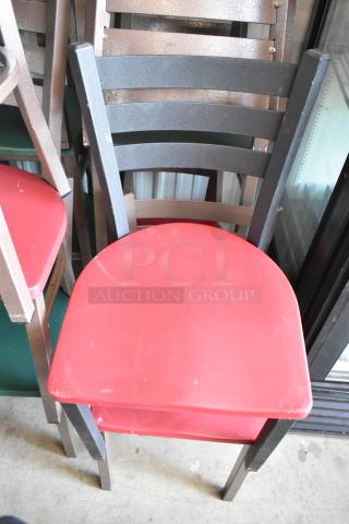 Metal dining chair with a red seat and ladder-back design, showing minor wear. Suitable for commercial or personal use.