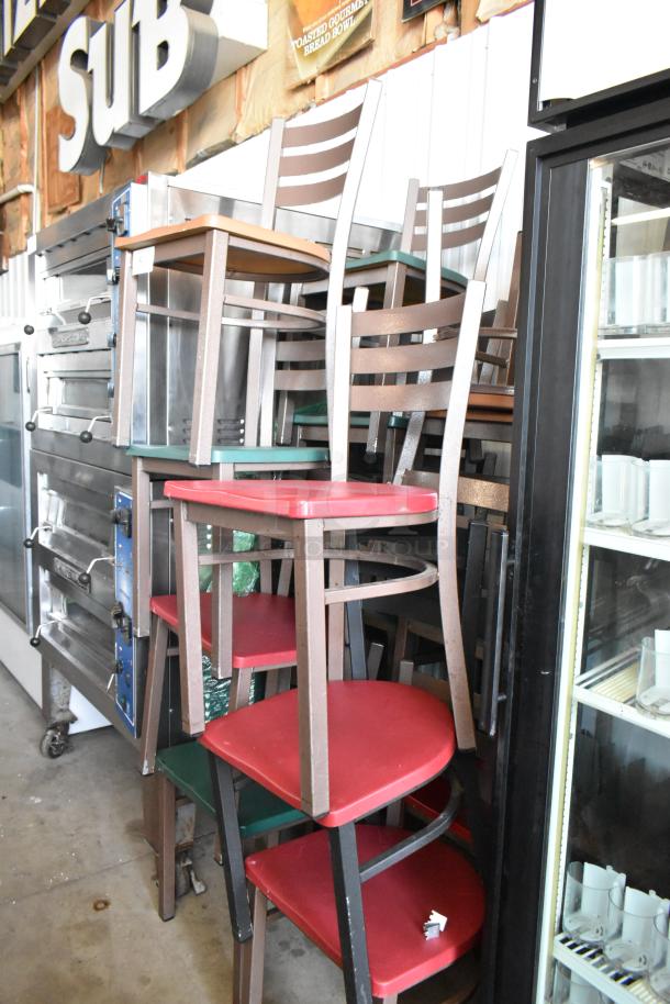 Stack of mixed restaurant chairs, brown frames, red and green seats; sturdy, used condition.