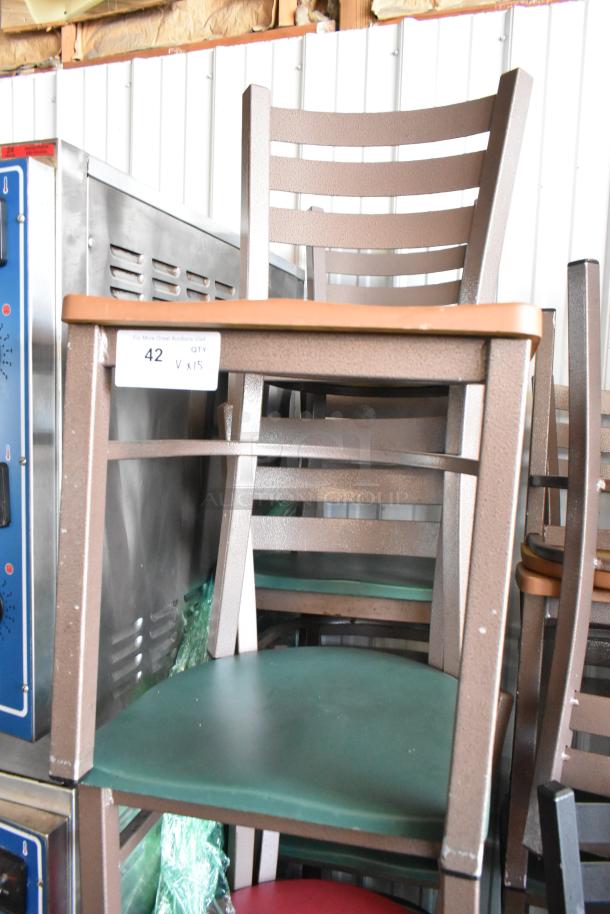 Stack of brown metal chairs with green seats, sturdy build, minor wear. Tag reads "42 QTY V x15" indicating quantity.